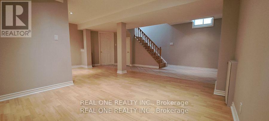 A spacious room with a staircase leading to the second floor.