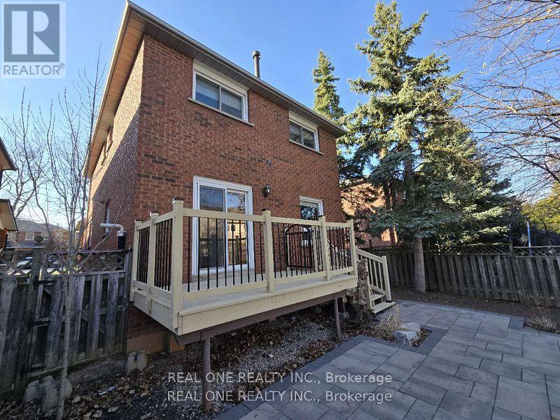 A house with a brick exterior and a deck in front.