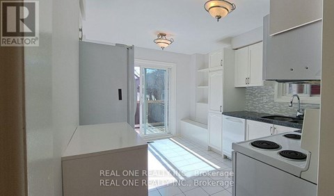A kitchen with white cabinets and a black stove top oven.
