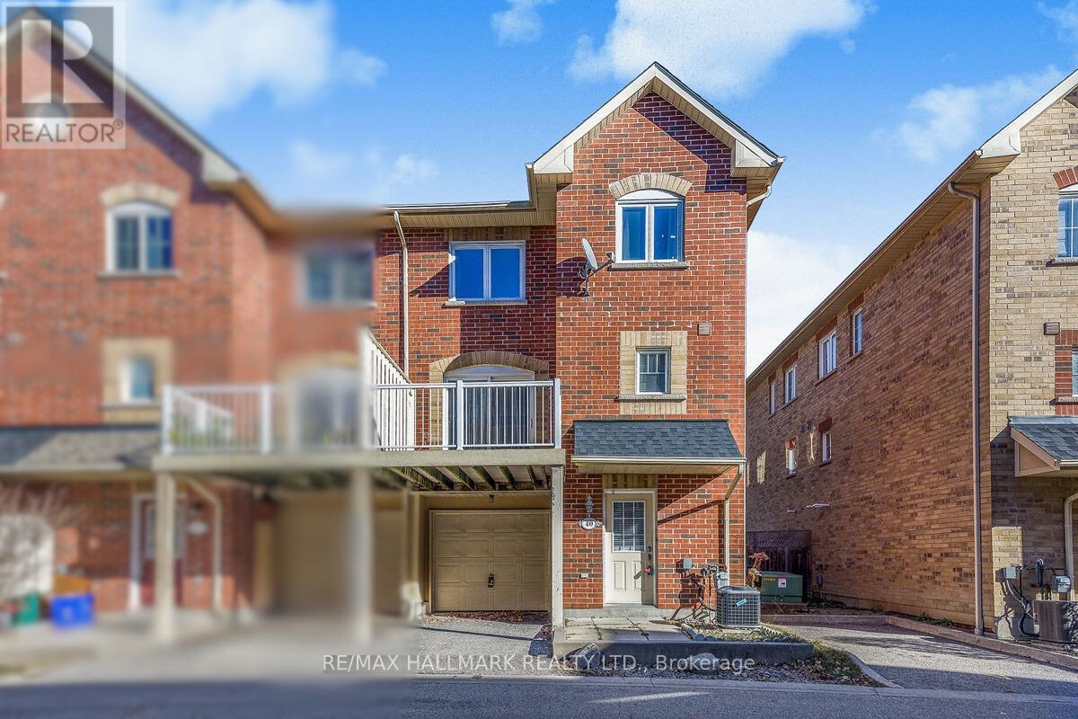 A red brick house with a balcony in the middle.