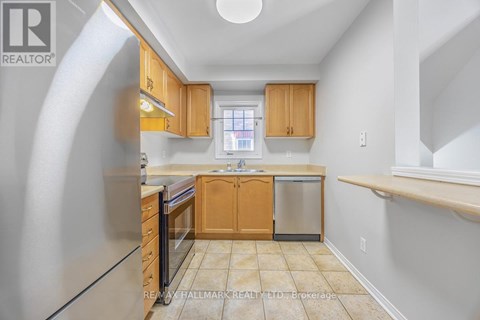 A kitchen with wooden cabinets and a stainless steel refrigerator.
