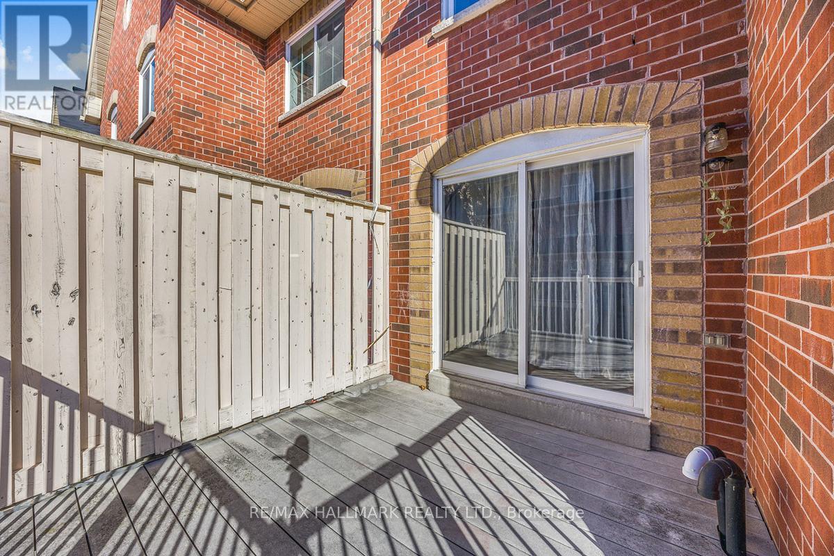 A wooden fence surrounds a brick building with a glass door.
