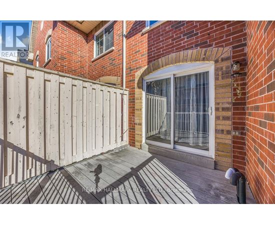 A wooden fence surrounds a brick building with a glass door.