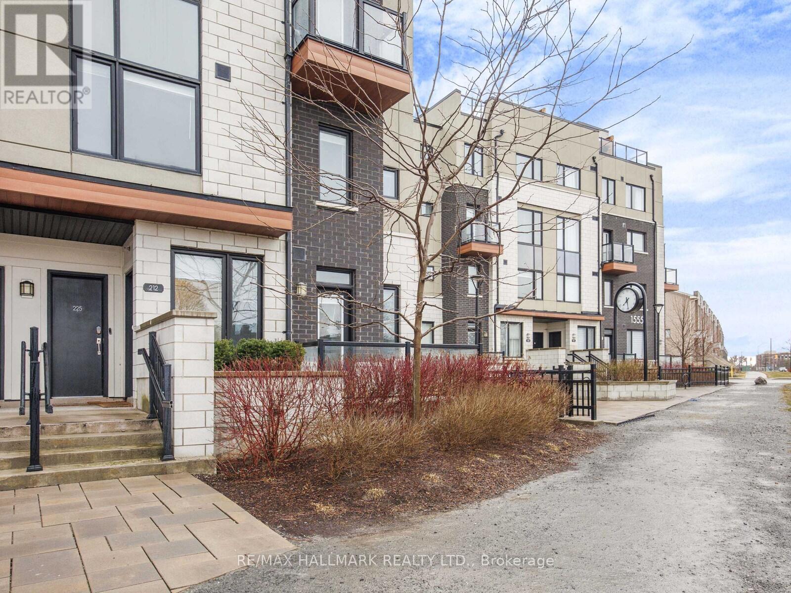 A row of modern townhouses with a clear sky above.