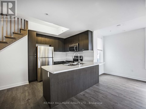 A modern kitchen with dark wood cabinets and a white island.