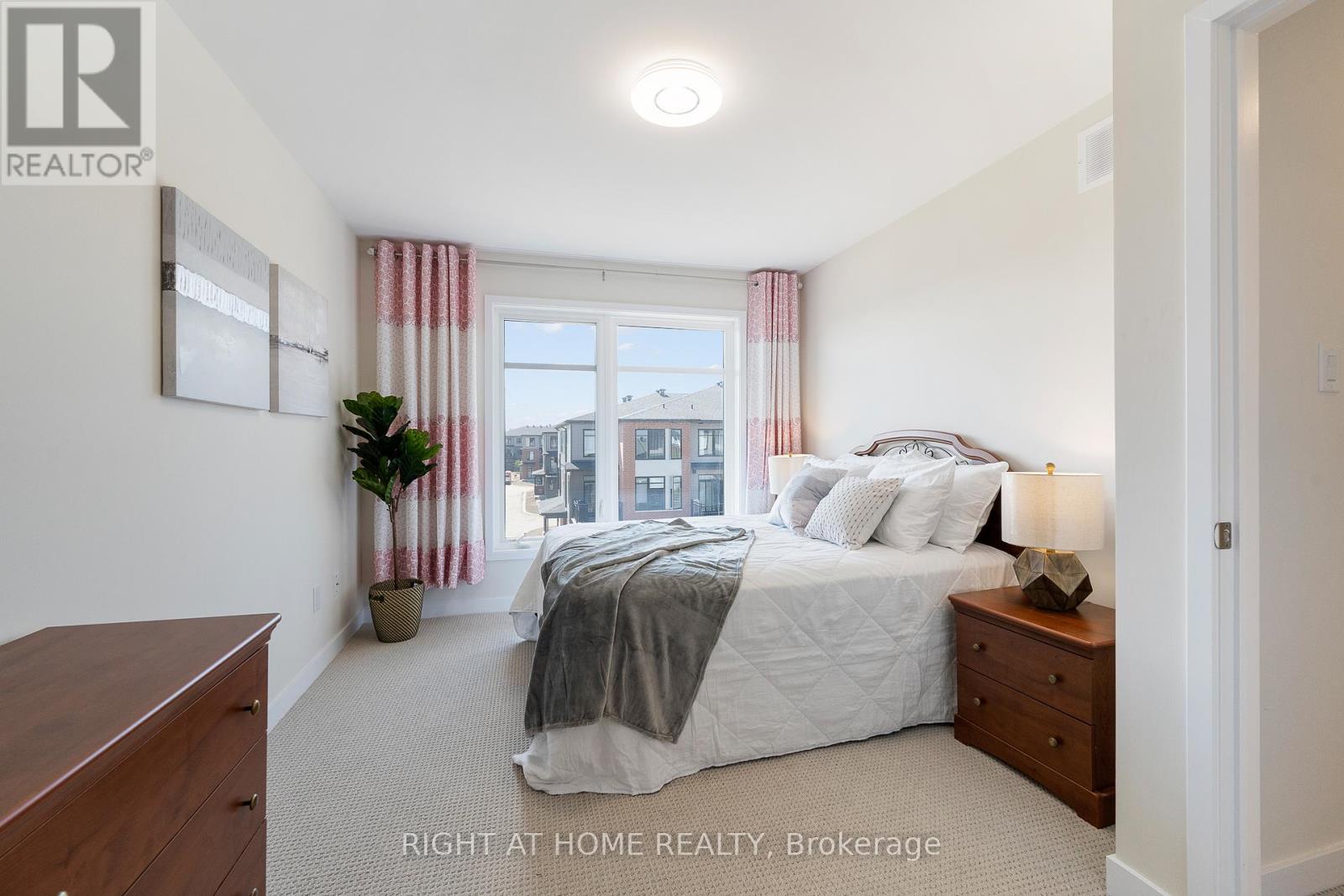 A bedroom with a large bed and a window with red curtains.
