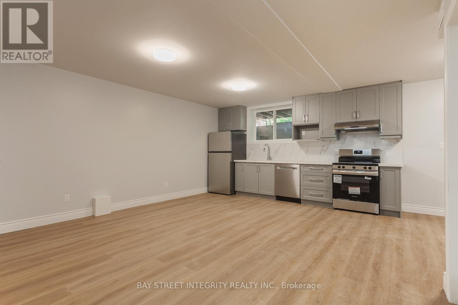 A kitchen with a stainless steel refrigerator, oven, and cabinets.