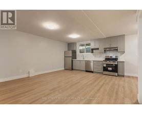 A kitchen with a stainless steel refrigerator, oven, and cabinets.