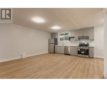 A kitchen with a stainless steel refrigerator, oven, and cabinets.