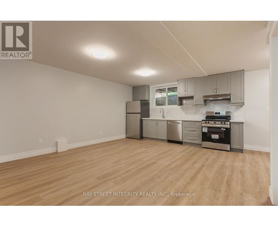 A kitchen with a stainless steel refrigerator, oven, and cabinets.