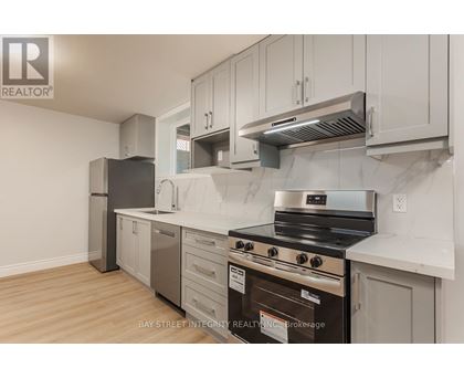 A kitchen with a stove top oven and a refrigerator.