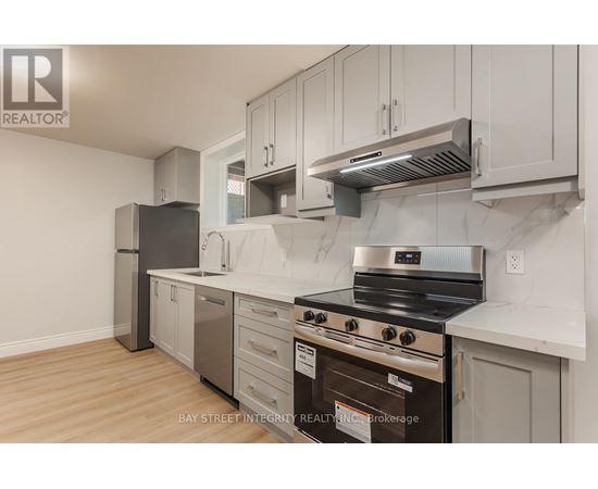 A kitchen with a stove top oven and a refrigerator.