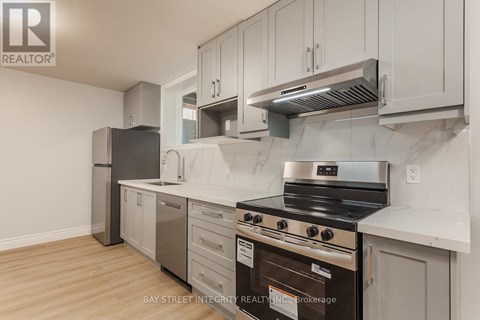 A kitchen with a stove top oven and a refrigerator.