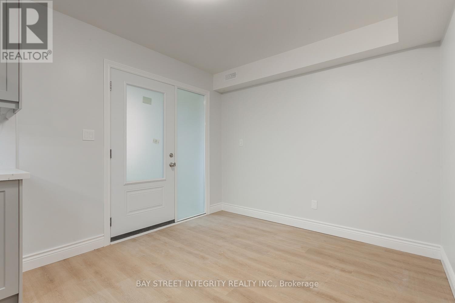 A room with a door and a window with a white wall.