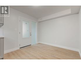 A room with a door and a window with a white wall.