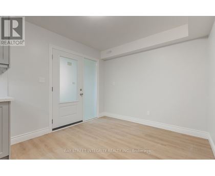 A room with a door and a window with a white wall.