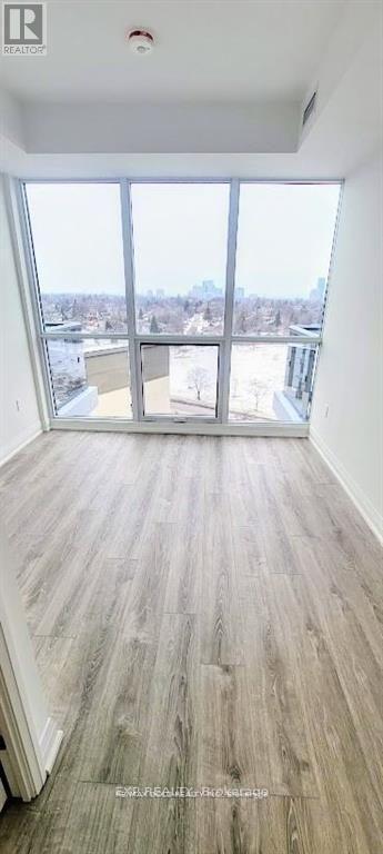 A room with a large window and wooden flooring.