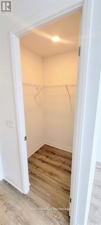 A white door is open to a room with a wooden floor.