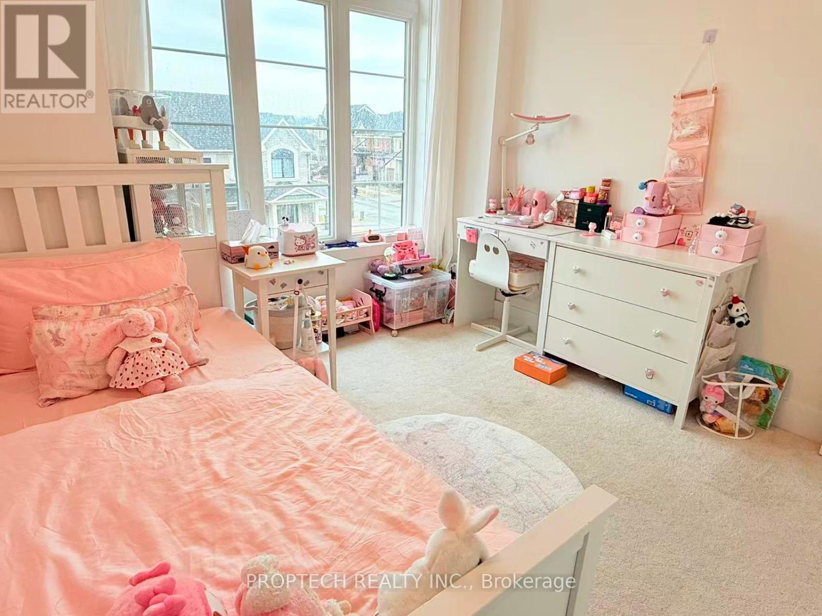 A bedroom with a bed, nightstand, and window.