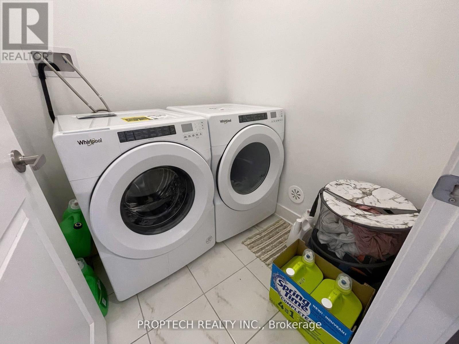 A white Whirlpool washing machine and dryer in a small laundry room.