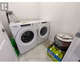 A white Whirlpool washing machine and dryer in a small laundry room.
