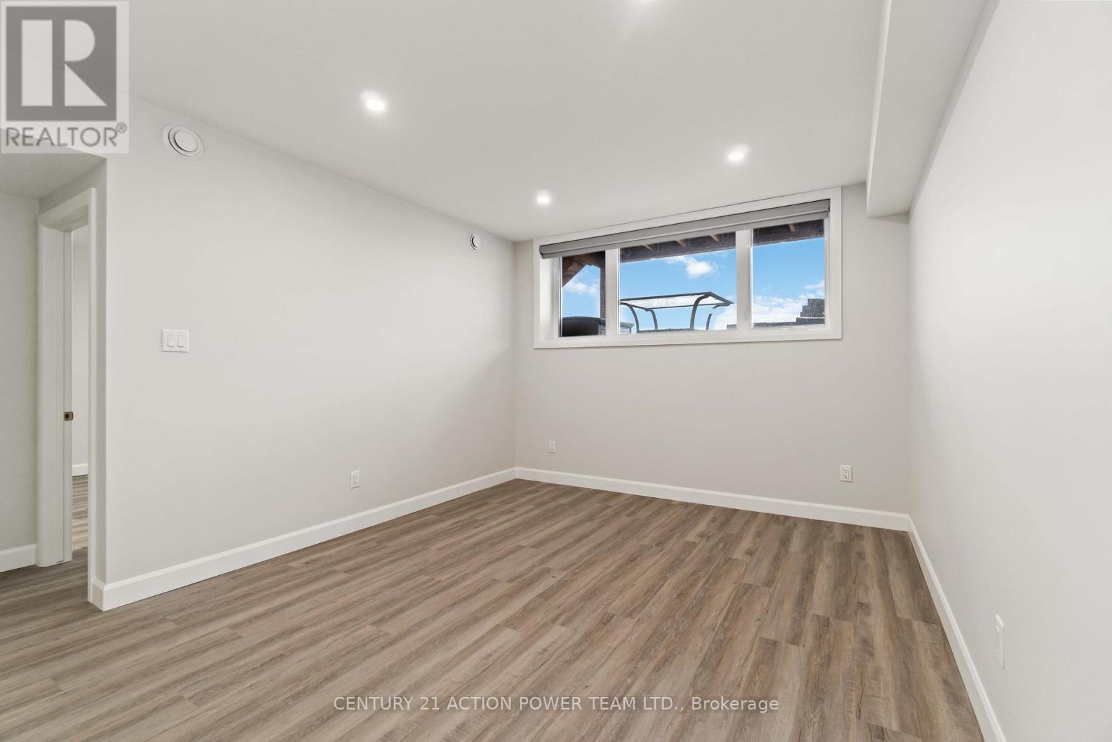 A room with a window showing a car and a building outside.