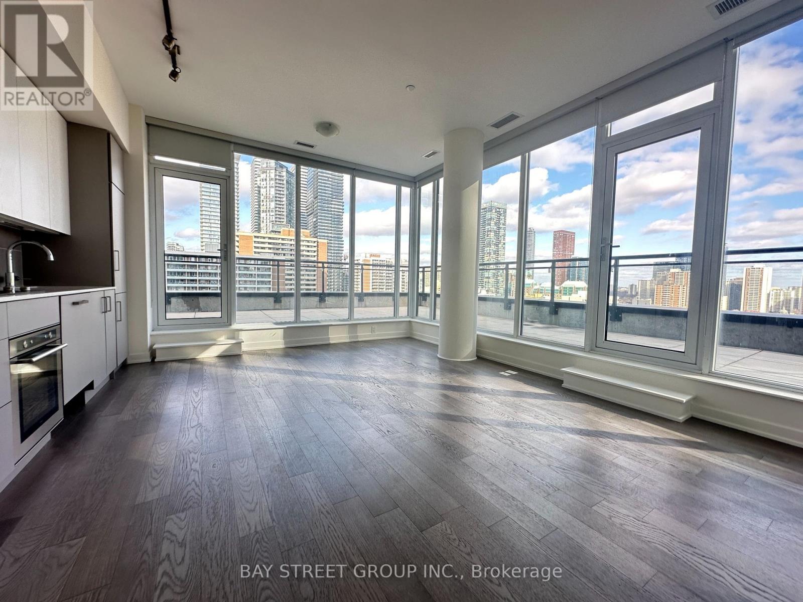 A spacious room with large windows overlooking a cityscape.