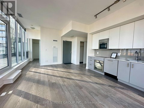 A spacious kitchen with white cabinets and a microwave above the oven.