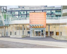 The image shows the front of a realty office with a glass facade and a large orange signboard.