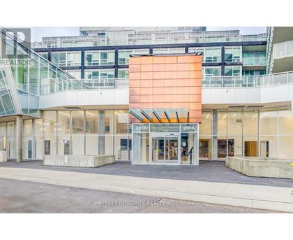 The image shows the front of a realty office with a glass facade and a large orange signboard.