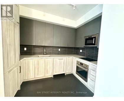 A kitchen with wooden cabinets and a black countertop.
