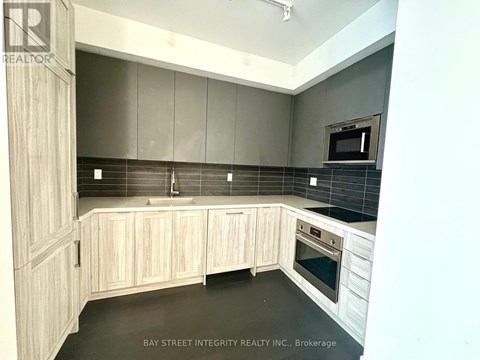 A kitchen with wooden cabinets and a black countertop.