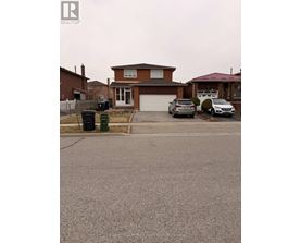A house with a brown roof and a driveway in front of it.