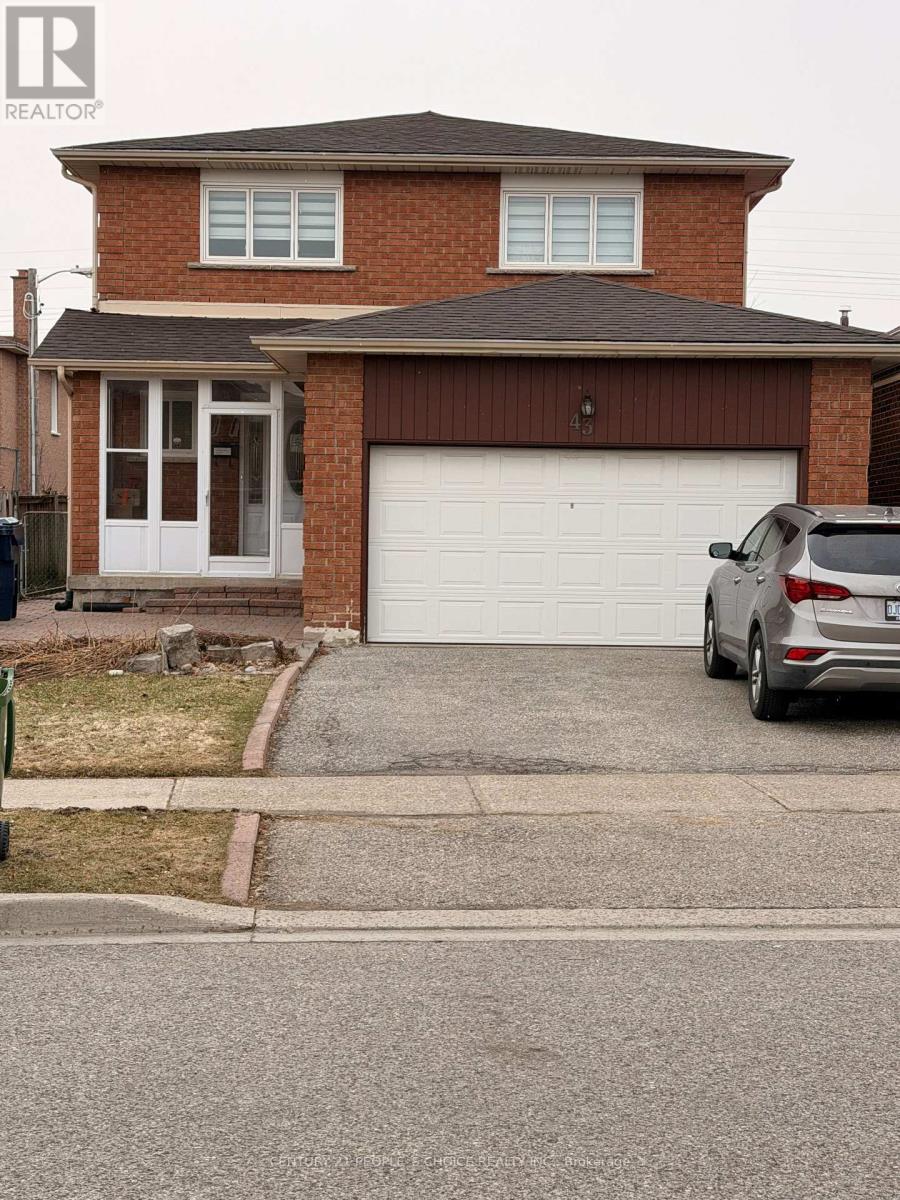 A house with a garage and a car parked in front.