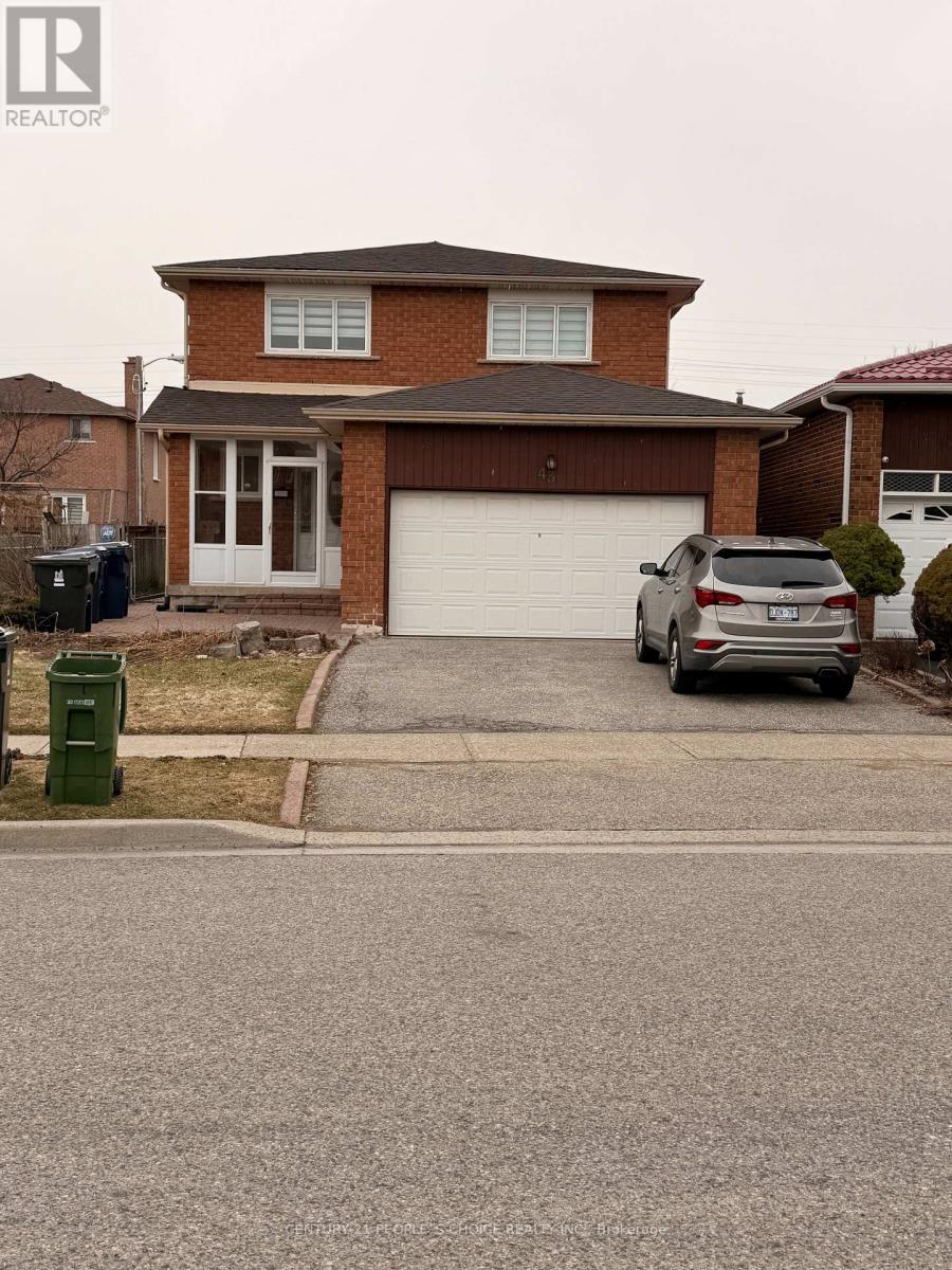 A house with a brown roof and a grey car parked in front.