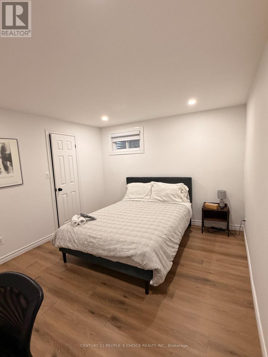 A bedroom with a bed, chair, and a small table.