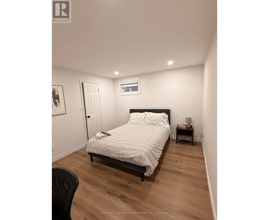 A bedroom with a bed, chair, and a small table.