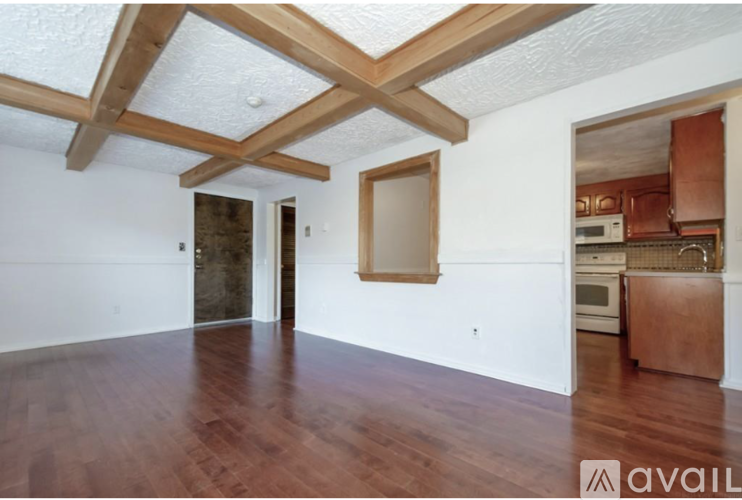 A room with wooden floors and a ceiling with wooden beams.