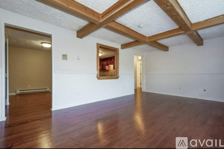 A room with wooden floors and a painting on the wall.