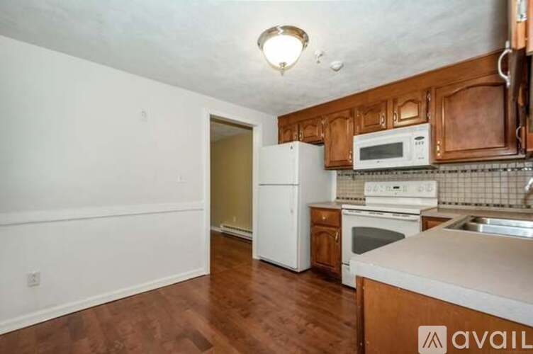 A kitchen with wooden cabinets and a white fridge.