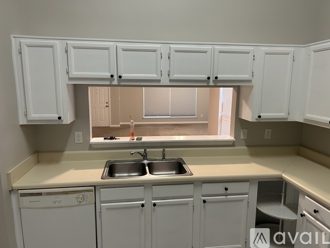 A kitchen with white cabinets and appliances.