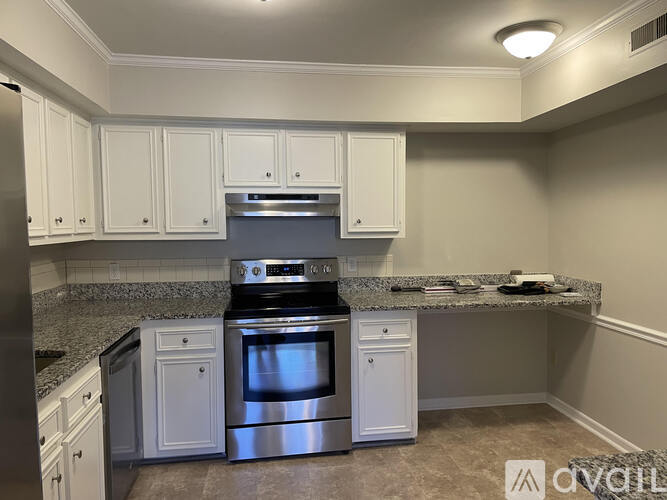 A kitchen with white cabinets and a granite countertop.