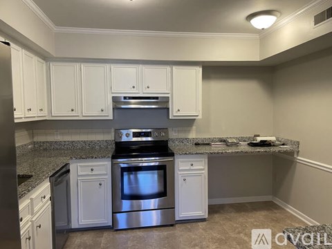 A kitchen with white cabinets and a granite countertop.