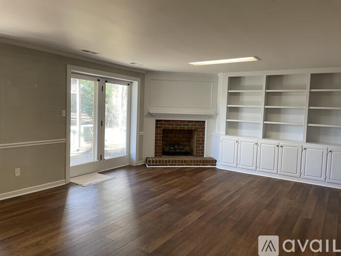 A living room with a fireplace and built-in shelves.