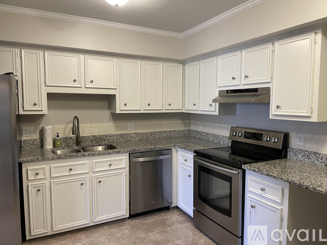 A kitchen with white cabinets and a black oven.