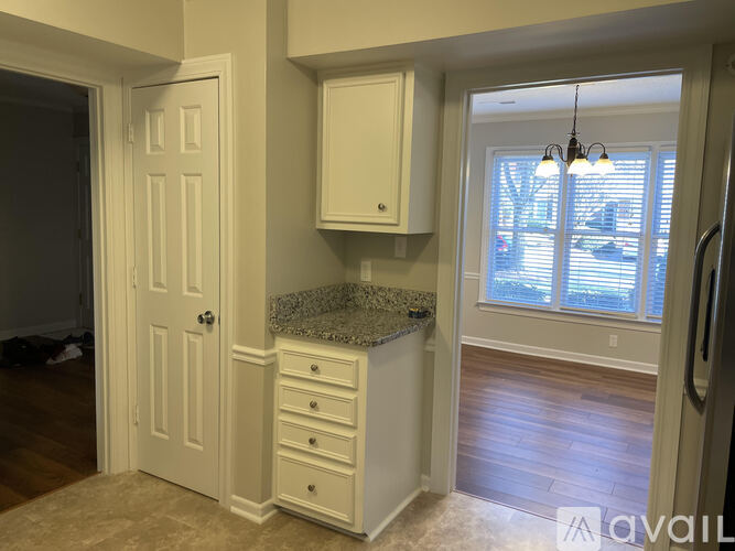 A kitchen with a granite countertop and white cabinets.