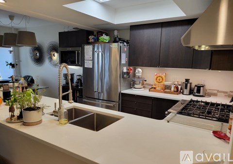 A modern kitchen with a stainless steel refrigerator and a white countertop.