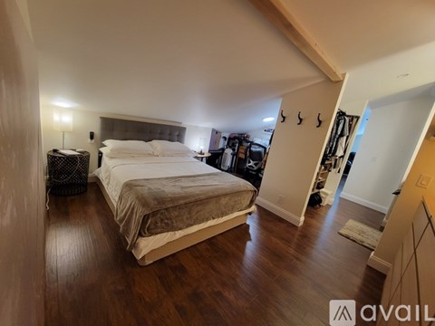 A bedroom with a bed, a nightstand, and a lamp.