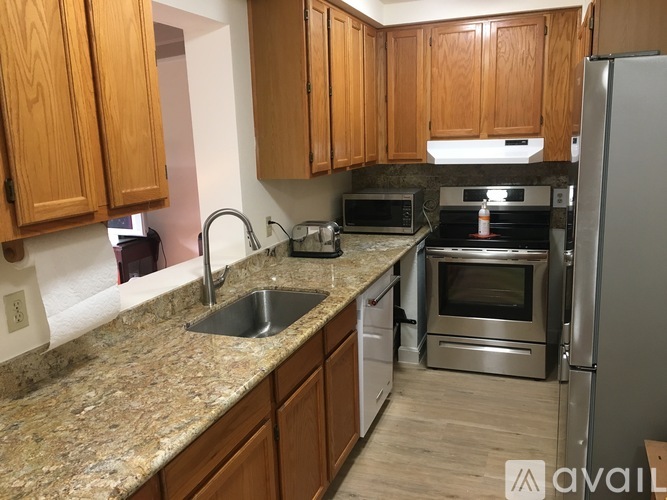 A kitchen with wooden cabinets and granite countertops.