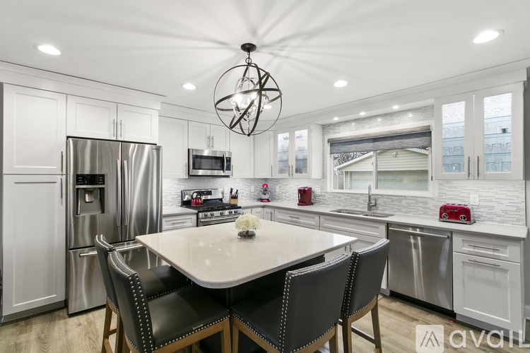 A modern kitchen with a large island and stainless steel appliances.